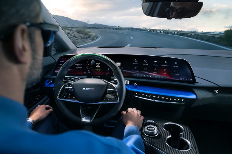 Front View of the 2026 OPTIQ-V Driving Through the Dusk Utilizing its Headlights | Ingersoll Cadillac of Danbury in Danbury CT